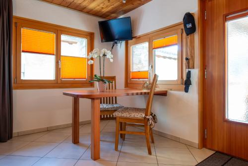 a dining room with a table and a tv at Fiesch, Ferienwohnung mit Aussensitzplatz in Fiesch