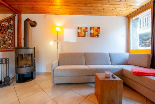 a living room with a couch and a fireplace at Fiesch, Ferienwohnung mit Aussensitzplatz in Fiesch