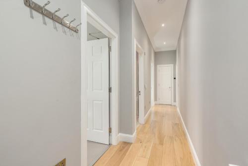 an empty hallway with white walls and wood floors at Destiny Scotland - Princes Street Residence in Edinburgh