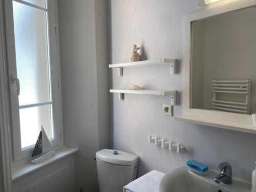Un baño con inodoro, lavabo y espejo. en Villa Patton, en Granville