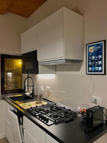 a kitchen with white cabinets and a stove top oven at La Tana di Orlando - Magical Dreams in Petralia Sottana