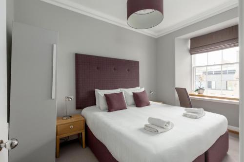 a bedroom with a large bed with towels on it at Destiny Scotland - Princes Street Residence in Edinburgh