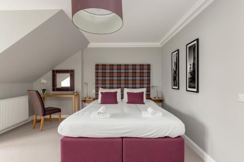 a bedroom with a large bed with pink pillows at Destiny Scotland - Princes Street Residence in Edinburgh