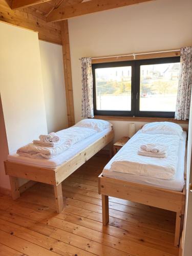 two beds in a room with a window at Apartments Steinwänd in Grünau im Almtal