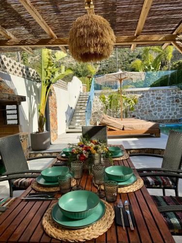 a wooden table with green plates on it on a patio at City Compass Sunset Villa in Rhodes Town
