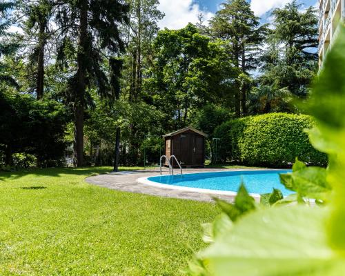a swimming pool in a yard next to a house at Flow Apartments WINKEL STUDIO in Merano