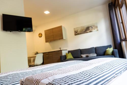 a bedroom with a bed and a couch at Flow Apartments WINKEL STUDIO in Merano