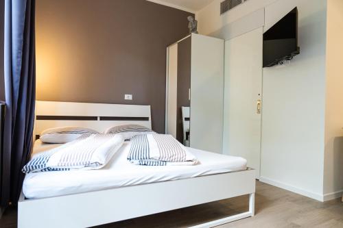 a bedroom with a white bed with a tv on it at Flow Apartments WINKEL STUDIO in Merano