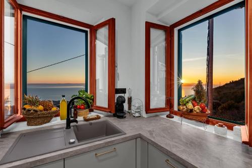 a kitchen with a view of the ocean through windows at Villa Natalija - Makarska Exklusiv in Baška Voda