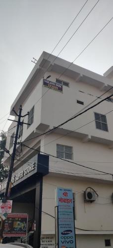 Un edificio blanco con un cartel delante. en Hotel Solam Inn, en Lucknow
