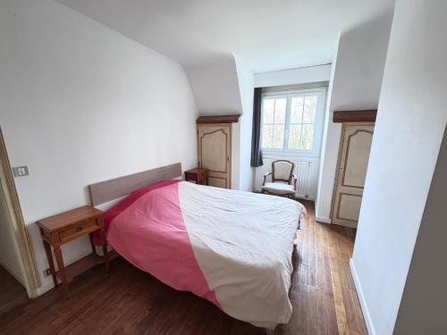 a bedroom with a bed with a pink blanket at Gîte du Grand Sancerrois in Jars