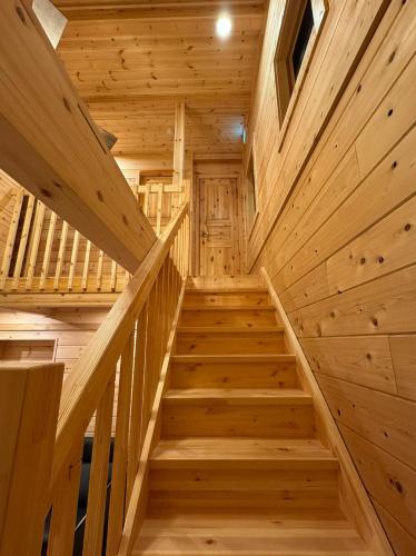 a staircase in a log cabin with wooden walls at P's Wood 箱根仙石原 in Hakone