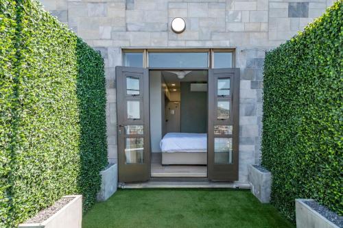 a bedroom is seen through two large bushes at Habitat Aparthotel by Totalstay in Cape Town