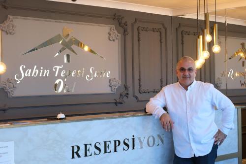 a man standing in front of a counter in a restaurant at Şahin Tepesi Suite Otel in Trabzon