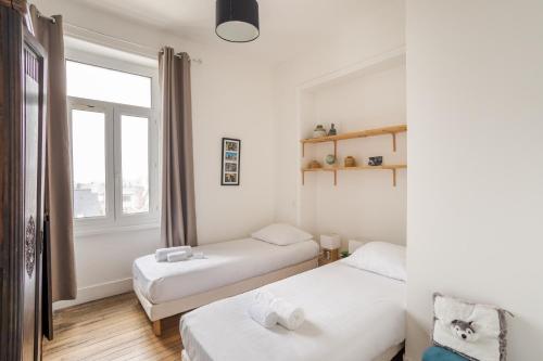 une chambre avec deux lits et une fenêtre dans l'établissement Odorico Malouin - A 5min de la plage, à Saint-Malo
