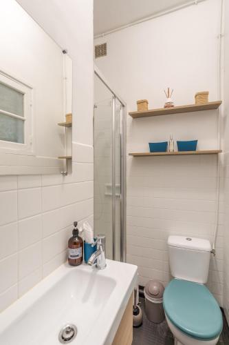 une salle de bain blanche avec des toilettes et un lavabo dans l'établissement Odorico Malouin - A 5min de la plage, à Saint-Malo