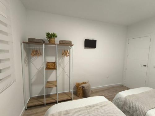 Habitación con estantería y TV en la pared. en Vivienda Turística La Cordobesa, en Córdoba