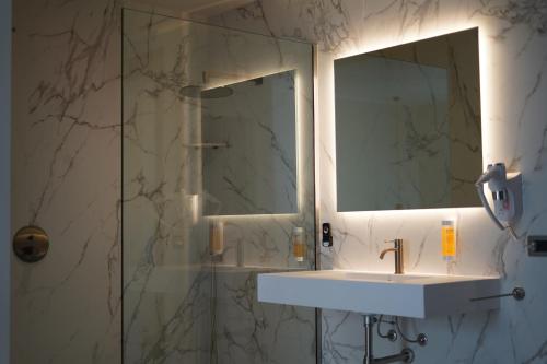 a bathroom with a sink and a shower with a mirror at Tenuta San Marco in Noto