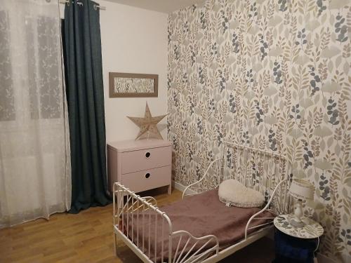 - une chambre avec un lit bébé, une commode et un rideau dans l'établissement home sweet home, à Savigny-le-Temple