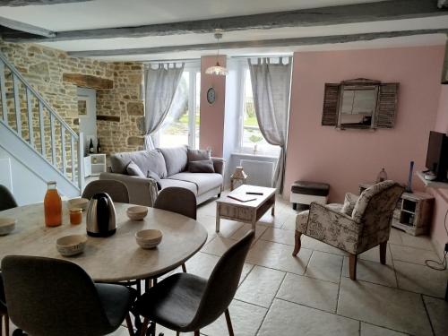 a living room with a couch and a table and chairs at La Ferme d' Emerentine in Bacilly