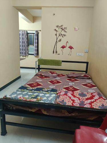 a bed with a quilt on it in a room at Shree Swa Cottage Revdanda in Alībāg