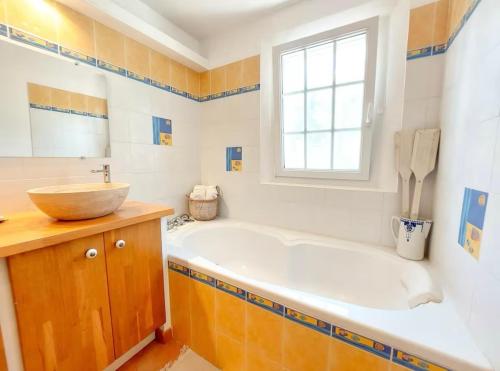 une salle de bain avec une baignoire, un lavabo et une fenêtre dans l'établissement L'Evasion Méditerranéenne - Villa Piscine, Proxi Plage & Commerces, au Pradet