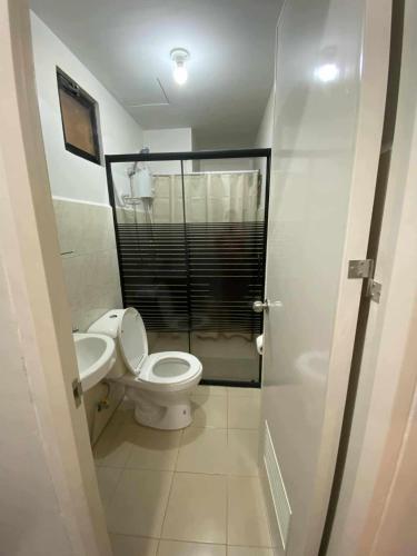 a small bathroom with a toilet and a sink at Jono's Flat Royal Oceancrest in Lapu Lapu City