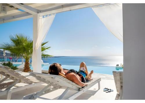 two people laying on a beach chair on the beach at Kaladi Rock Ammos in Avlemonas