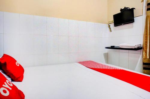 a red and white bed in a room at Collection O Darussalam Near Universitas Syiah Kuala Formerly Meurah Mulia in Banda Aceh