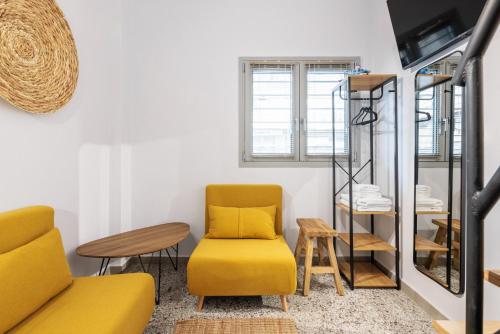 a living room with a yellow chair and a table at Boho Rooms in Thessaloniki