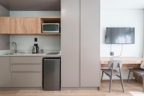 a kitchen with a counter and a table and a chair at Habitat Aparthotel by Totalstay in Cape Town