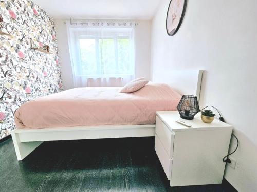 a bedroom with a bed and a clock on the wall at Le cocon decinois in Décines-Charpieu