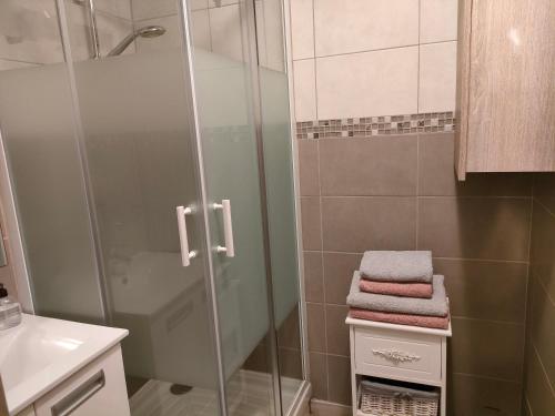 a bathroom with a shower and some towels on a shelf at Résidence MONTE CARLO in Châtelaillon-Plage