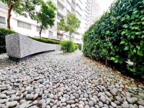a cobblestone walkway with rocks and bushes and buildings at Koi Kinrara 2 Room Puchong IOI Bkt Jalil Pavillion Sunway Pyramid Lagoon Hospital Old Klang Road in Puchong
