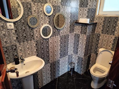 a bathroom with a sink and a toilet and mirrors at Casa Miami in Tarrafal