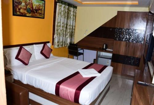 a bedroom with a large bed in a room at AR Grand HOTEL in Rājgīr