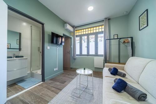 un salon avec un canapé et une cuisine dans l'établissement Studio raffiné - Aix hypercentre, à Aix-en-Provence