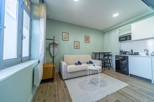 un salon avec un canapé et une cuisine dans l'établissement Studio raffiné - Aix hypercentre, à Aix-en-Provence