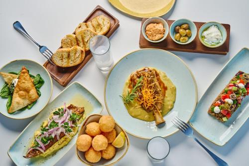 a table topped with plates of food and bowls of food at Lindos Royal Resort in Líndos
