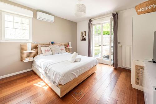 une chambre avec un grand lit avec des draps blancs dans l'établissement Fairway Villa Disneyland, à Magny-le-Hongre