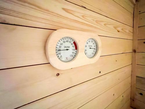two clocks on the wall of a cabin at The Farmhouse Private HOT TUB & SAUNA & TV-CINEMA Room Very Special Home Near Cannock Chase in Colton