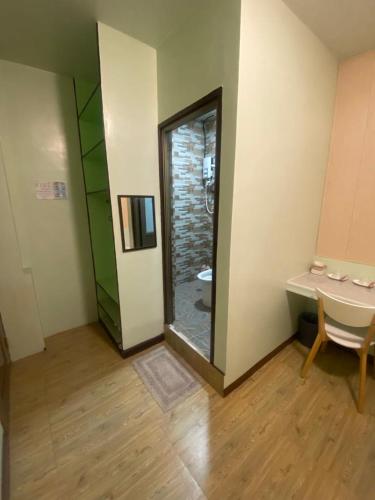 a room with a bathroom with a toilet and a mirror at Calia’s Transient House in La Trinidad