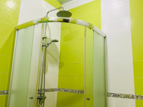 a shower in a bathroom with yellow and white tiles at SD Hotel in Yerevan