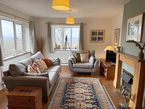a living room with a couch and chairs and a fireplace at Yew Tree Cottage - walks from the door in Colwall