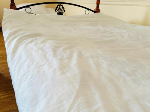 a white bed with a black headboard and white sheets at SD Hotel in Yerevan
