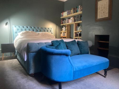ein blaues Sofa in einem Schlafzimmer mit einem Bett in der Unterkunft Gavin's Sea Pad in St. Leonards