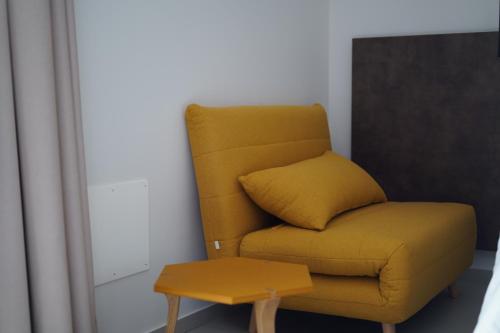 a yellow chair in a room with a table at Tenuta San Marco in Noto