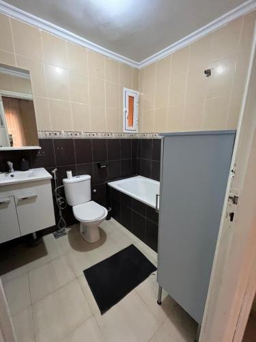 a bathroom with a toilet and a tub and a sink at Un appartement cosy in Oujda
