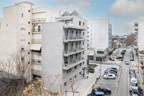 a tall white building with cars parked on a street at Boho Rooms in Thessaloniki