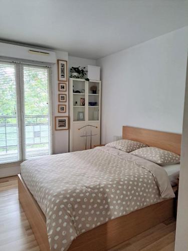 une chambre avec un grand lit et une fenêtre dans l'établissement Apt terrace Paris Sud 300m des transport, à Issy-les-Moulineaux